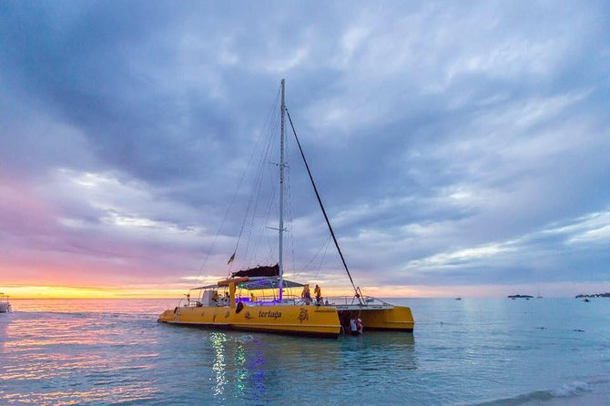 Catamaran Cruise Full Day Tour to Reef, Caves and Negril Beach - Boarding the catamaran in shallow water